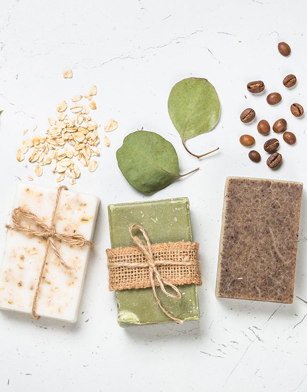 Selección de tres jabones naturales sobre fondo blanco. Copos de avena, eucalipto, oliva, jabón de café.